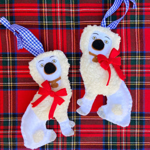 Pair of Staffordshire poodle ornaments on a tartan plaid background