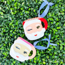 Load image into Gallery viewer, Red and Pink Winking Santa Mug Ornaments on Greenery